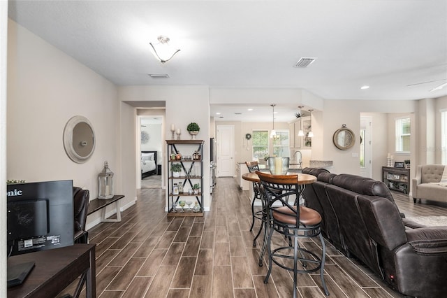 living room with ceiling fan, sink, and dark hardwood / wood-style floors