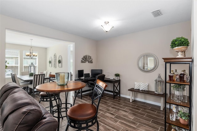 dining room with dark hardwood / wood-style floors and a notable chandelier