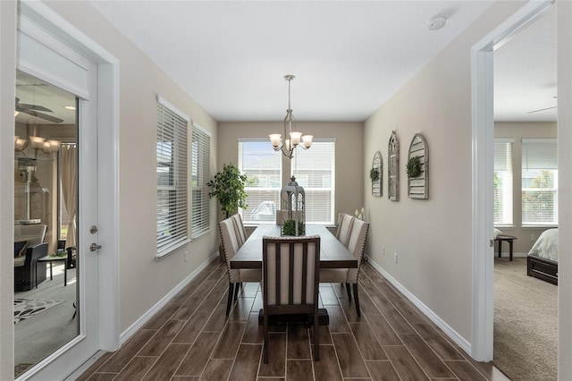 dining space with dark wood-type flooring and a chandelier