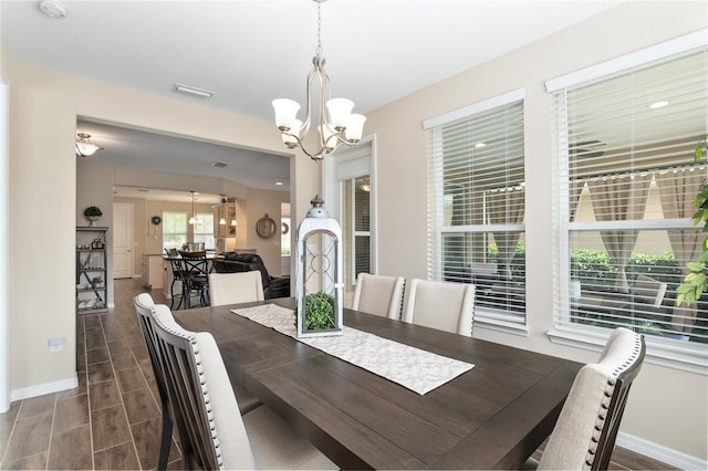 dining room with dark hardwood / wood-style flooring and a notable chandelier