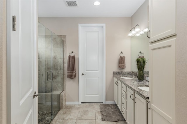 bathroom featuring tile patterned flooring, vanity, and an enclosed shower