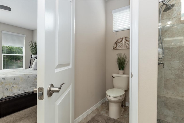 bathroom with a tile shower, toilet, and tile patterned floors