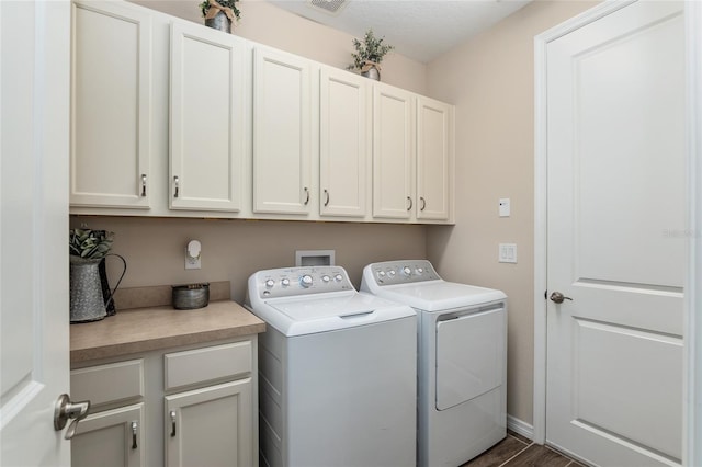 washroom with washer and dryer, dark hardwood / wood-style flooring, cabinets, and a textured ceiling