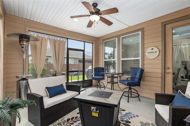 sunroom featuring ceiling fan and wood ceiling