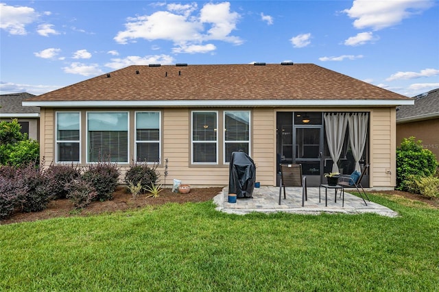 rear view of property with a lawn and a patio