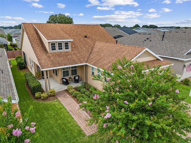 rear view of house with a lawn and a patio