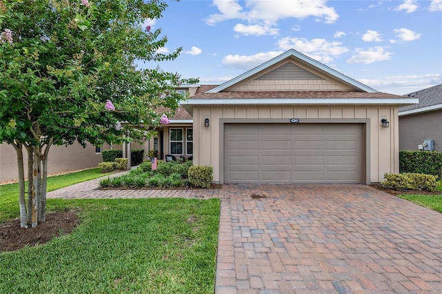 ranch-style home featuring a garage and a front lawn