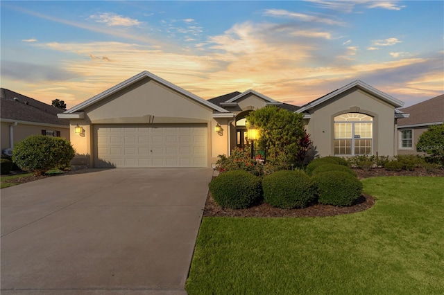 single story home featuring a garage and a yard