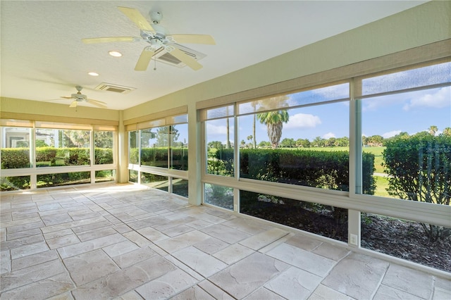 unfurnished sunroom with ceiling fan