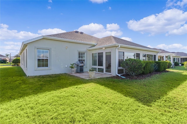 back of property with a lawn and a patio