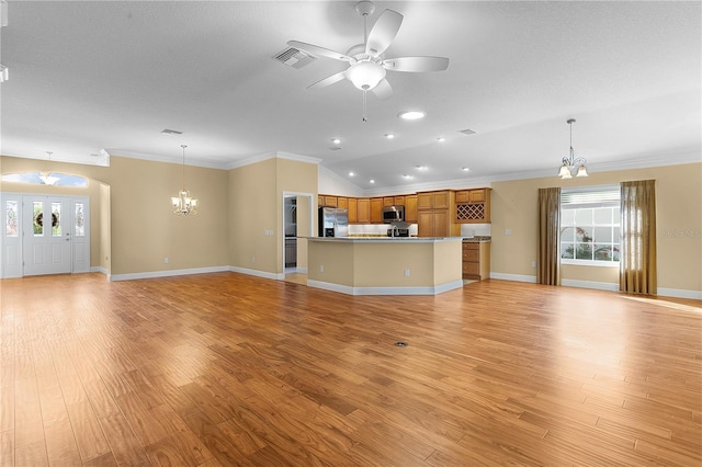 unfurnished living room featuring ceiling fan with notable chandelier, light hardwood / wood-style floors, ornamental molding, and vaulted ceiling