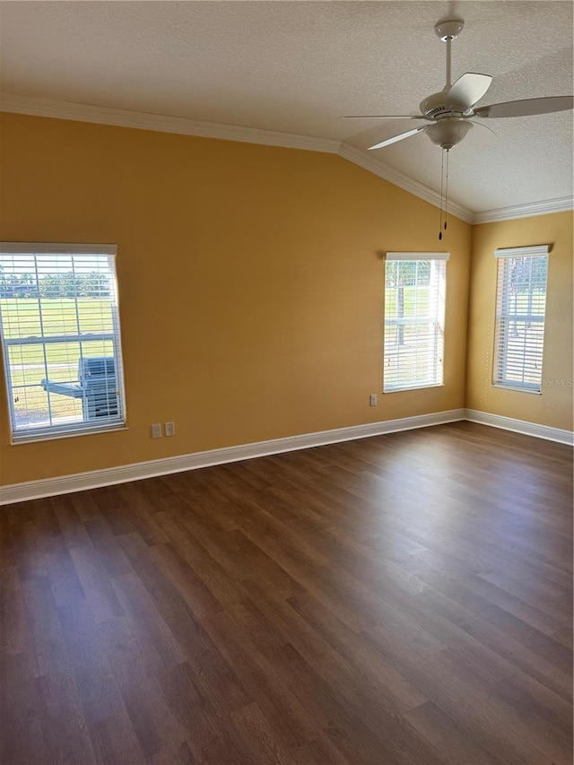 empty room with ceiling fan, dark wood-type flooring, crown molding, a textured ceiling, and lofted ceiling