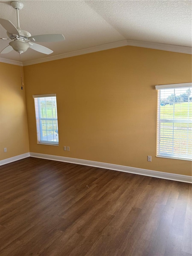 spare room with ornamental molding, dark wood-type flooring, lofted ceiling, and a healthy amount of sunlight