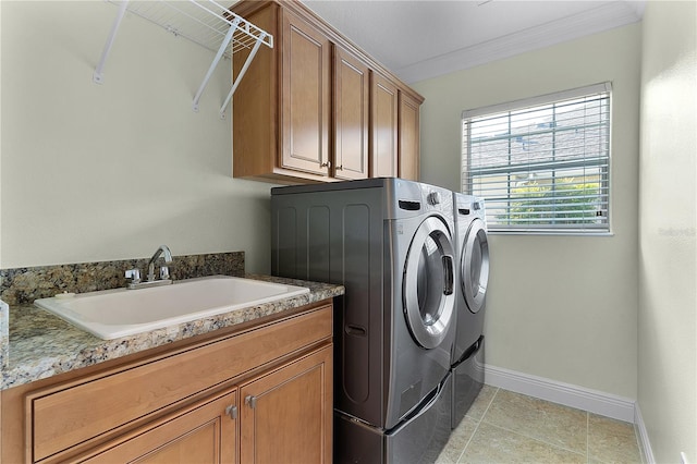 laundry room with cabinets, crown molding, sink, washer and dryer, and light tile patterned floors