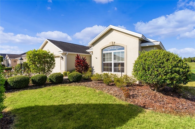 single story home with a garage and a front lawn