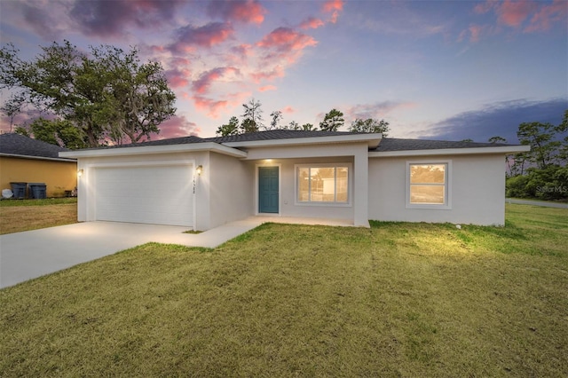 view of front of home featuring a garage and a yard