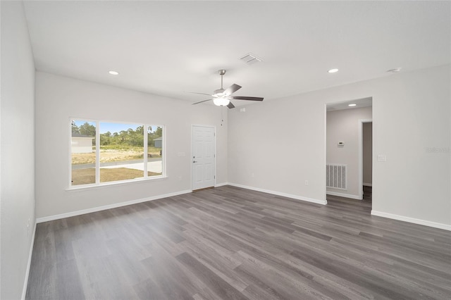 spare room featuring ceiling fan and dark wood-type flooring