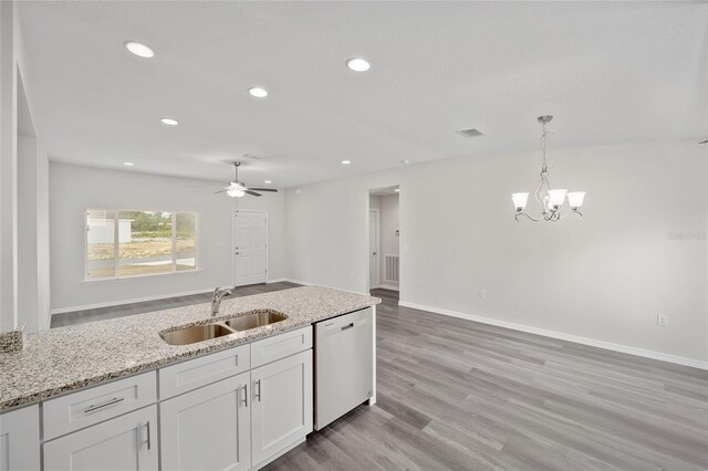 kitchen featuring light stone countertops, white cabinetry, sink, stainless steel dishwasher, and ceiling fan with notable chandelier