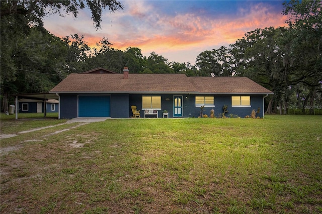 ranch-style house with a garage and a yard