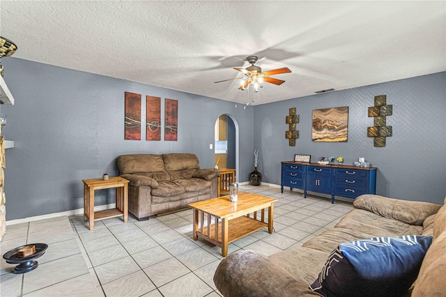 living room featuring light tile patterned floors, a textured ceiling, and ceiling fan