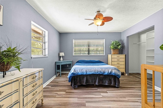 bedroom with hardwood / wood-style floors, a textured ceiling, and ceiling fan