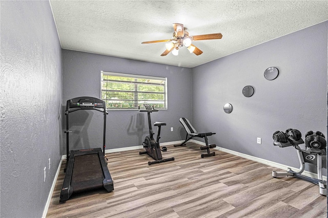 workout room with ceiling fan, a textured ceiling, and light hardwood / wood-style flooring