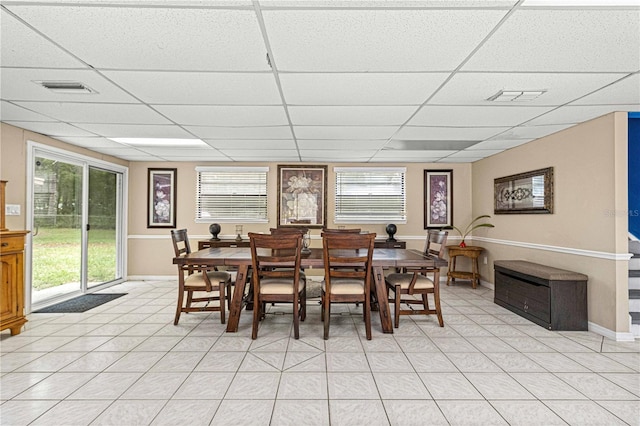 tiled dining space featuring a wealth of natural light and a paneled ceiling