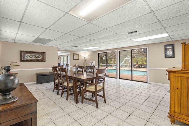 tiled dining area with a drop ceiling