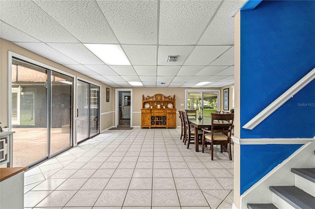 interior space with a drop ceiling and tile patterned floors