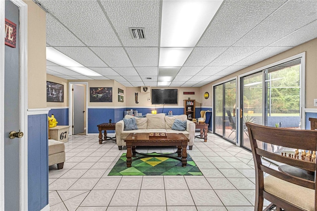 tiled living room featuring a drop ceiling