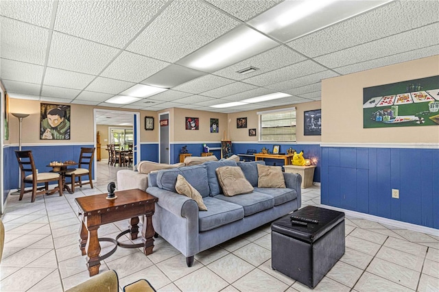 living room featuring a paneled ceiling and tile patterned floors