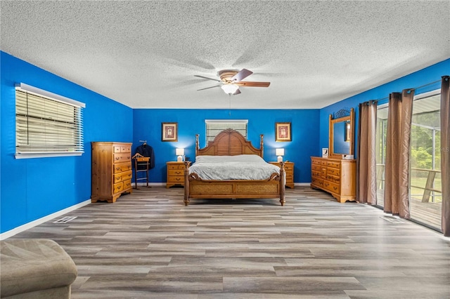 unfurnished bedroom featuring access to outside, a textured ceiling, ceiling fan, and light hardwood / wood-style flooring