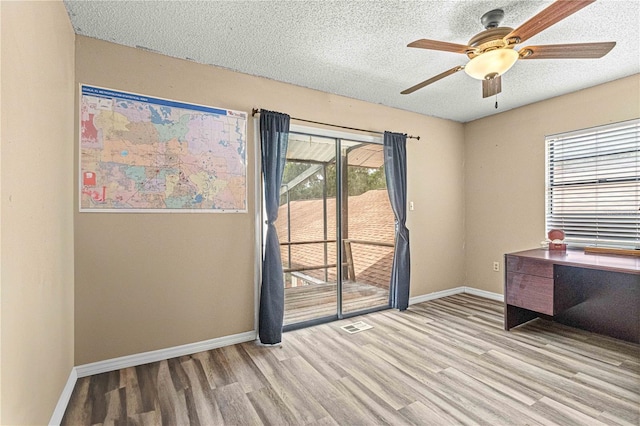 unfurnished office featuring ceiling fan, a textured ceiling, and light hardwood / wood-style floors