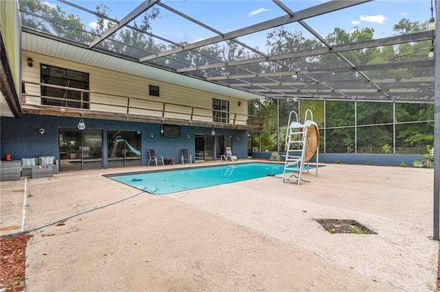 view of pool with a patio area, glass enclosure, and a water slide