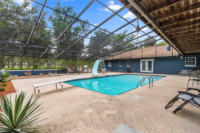 view of pool featuring a diving board, a patio, glass enclosure, and a water slide