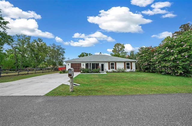 ranch-style home with a garage and a front lawn