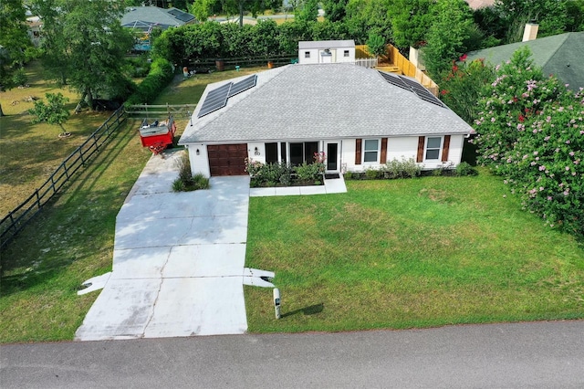 view of front facade with solar panels, a garage, and a front lawn