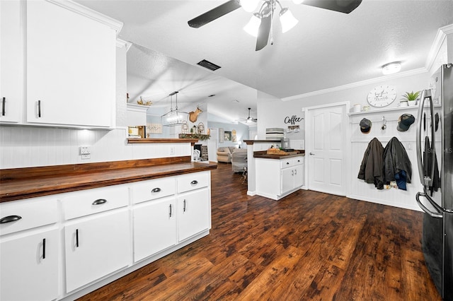 kitchen with white cabinets, wood counters, dark hardwood / wood-style floors, and stainless steel refrigerator