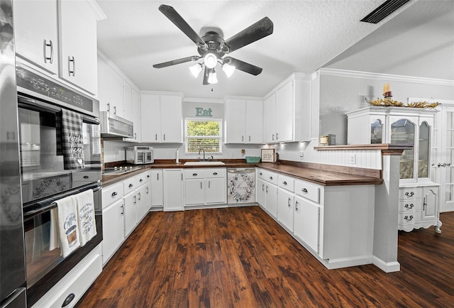 kitchen featuring dishwashing machine, black double oven, white cabinets, and sink