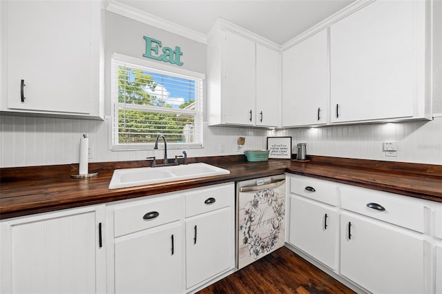 kitchen featuring dishwasher, white cabinets, sink, ornamental molding, and butcher block countertops