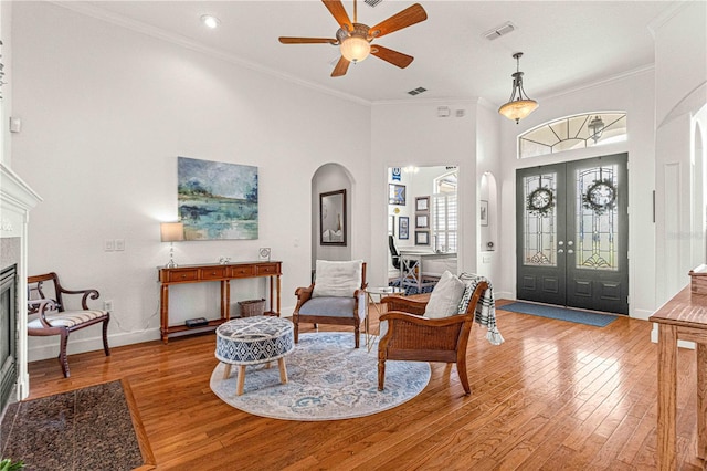 foyer entrance with french doors, ceiling fan, ornamental molding, and light hardwood / wood-style floors