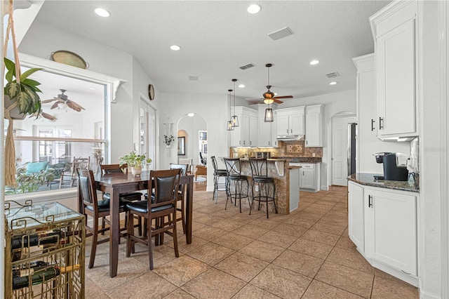 tiled dining space featuring ceiling fan