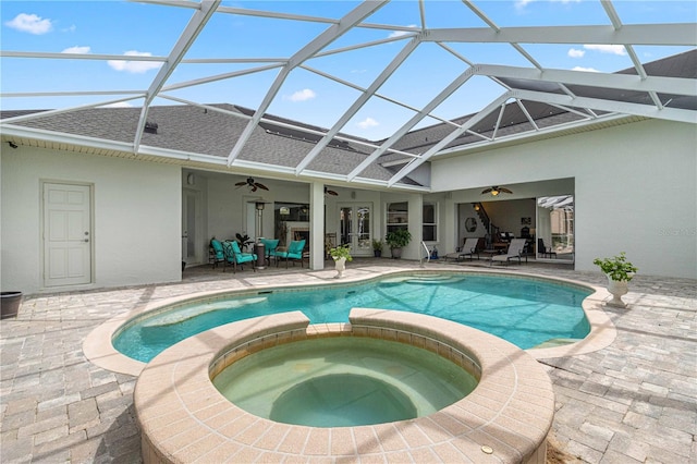 rear view of property with ceiling fan, a swimming pool with hot tub, a lanai, and a patio area