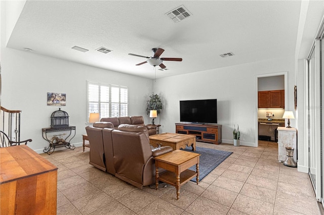 living room featuring a textured ceiling and ceiling fan