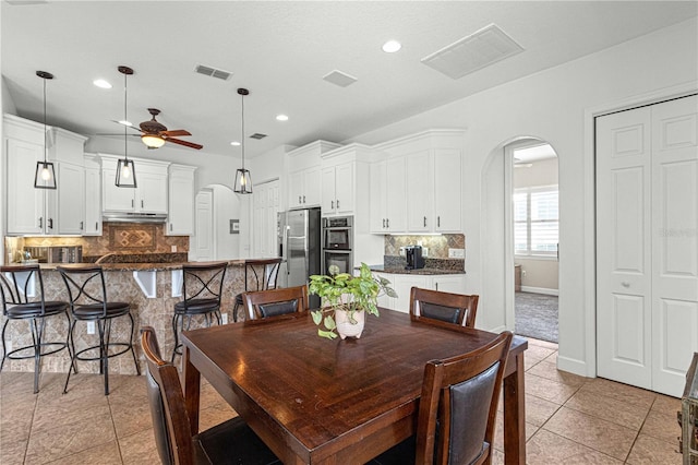 dining room featuring light tile patterned floors, a ceiling fan, visible vents, recessed lighting, and arched walkways