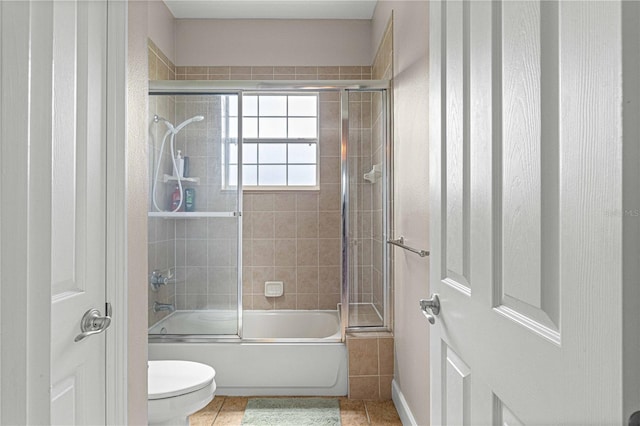 full bath with enclosed tub / shower combo, tile patterned flooring, and toilet