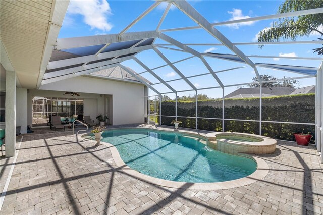 view of swimming pool with a patio, a lanai, a ceiling fan, and a pool with connected hot tub