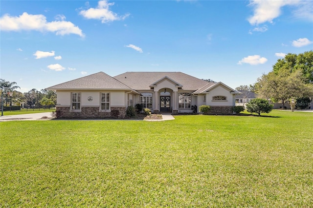 view of front of property featuring stone siding, stucco siding, and a front yard