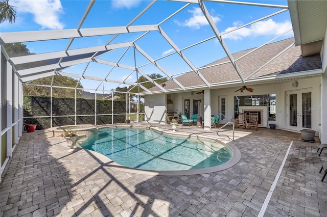 view of swimming pool with a ceiling fan, a pool with connected hot tub, french doors, a lanai, and a patio area