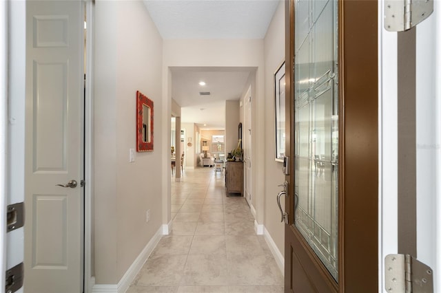 hall with light tile patterned floors